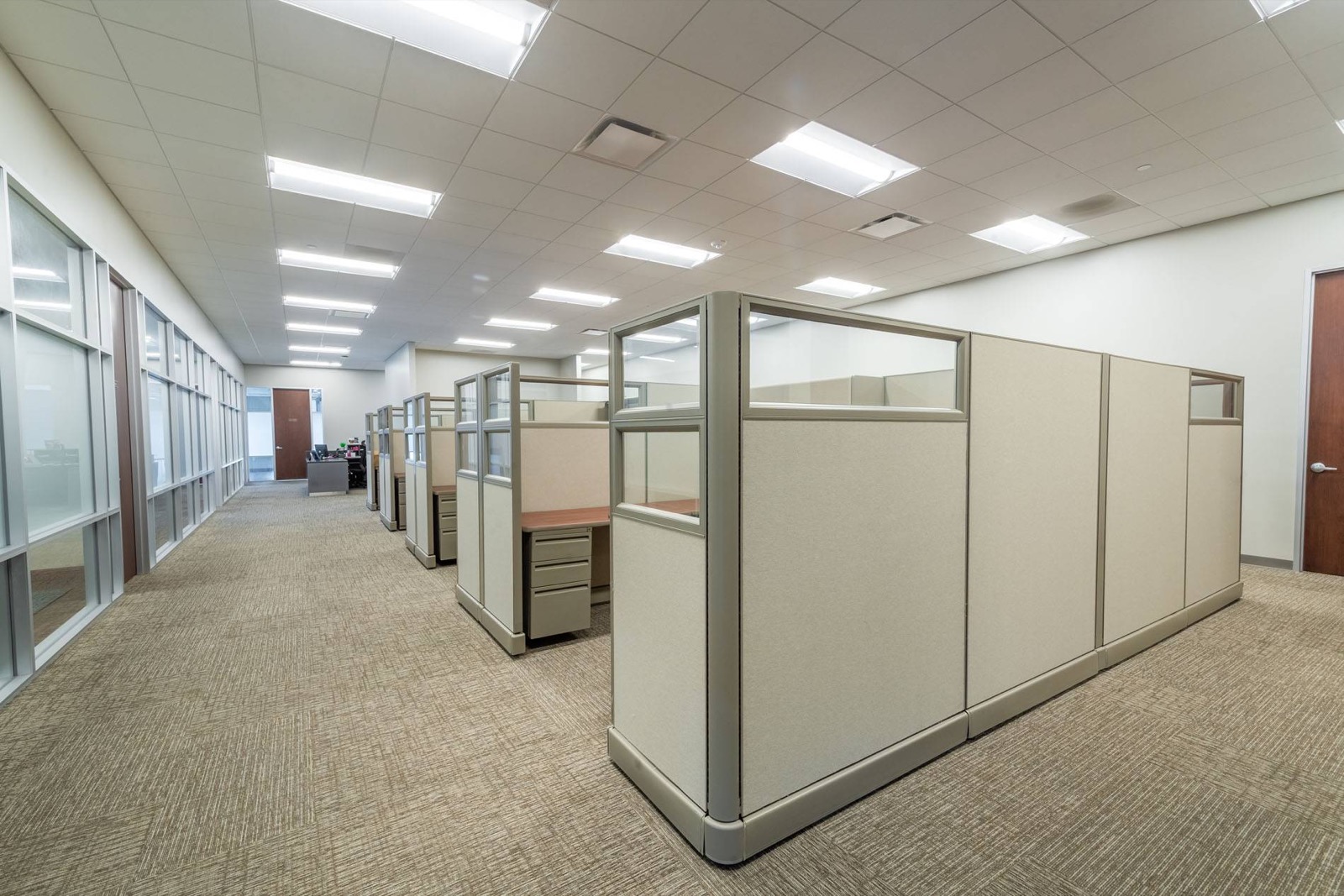 A finished installation of glass-topped cubicles on an open office floor